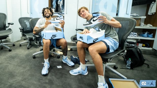 North Carolina basketball players open Air Jordan shoe boxes.